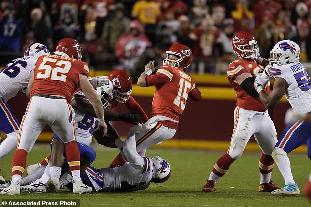 Kansas City Chiefs quarterback Patrick Mahomes (15) throws as he is hit during the second half of an NFL football game against the Buffalo Bills Sunday, Dec. 10, 2023, in Kansas City, Mo. (AP Photo/Charlie Riedel)